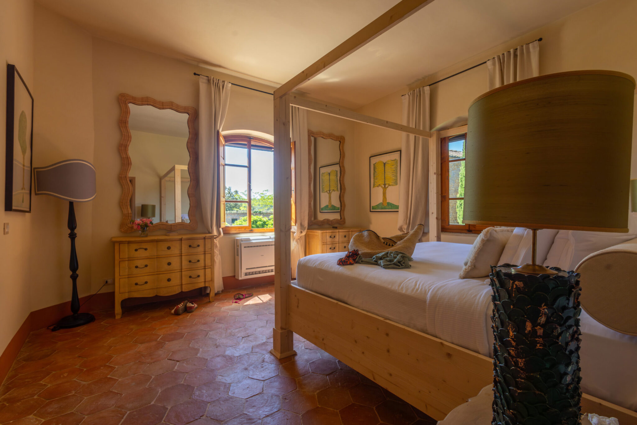 Bedroom at Villa Piaggia with a wooden four-poster bed and terracotta floor
