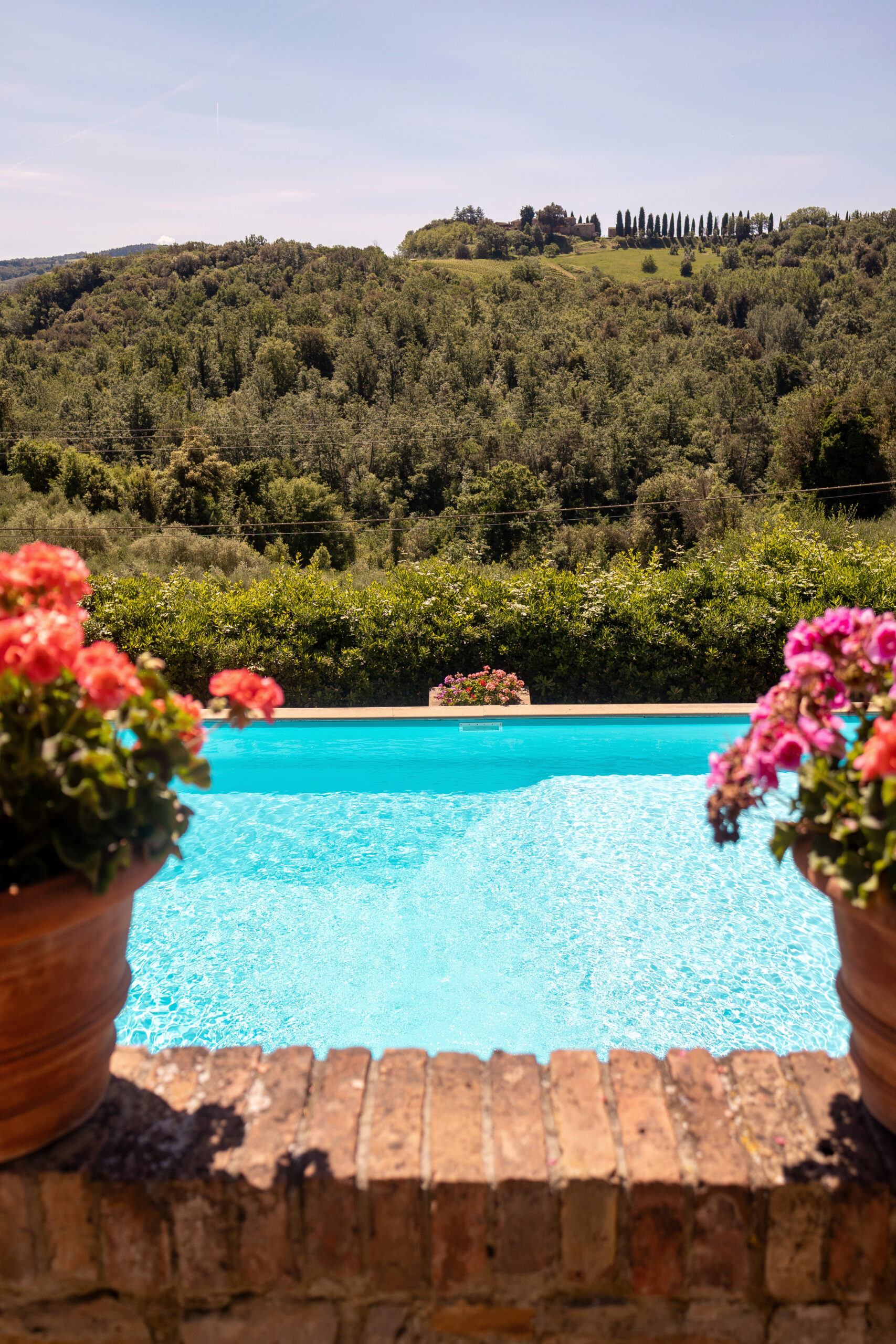 La piscina di Villa Piaggia con vista sul casale in pietra e sul giardino