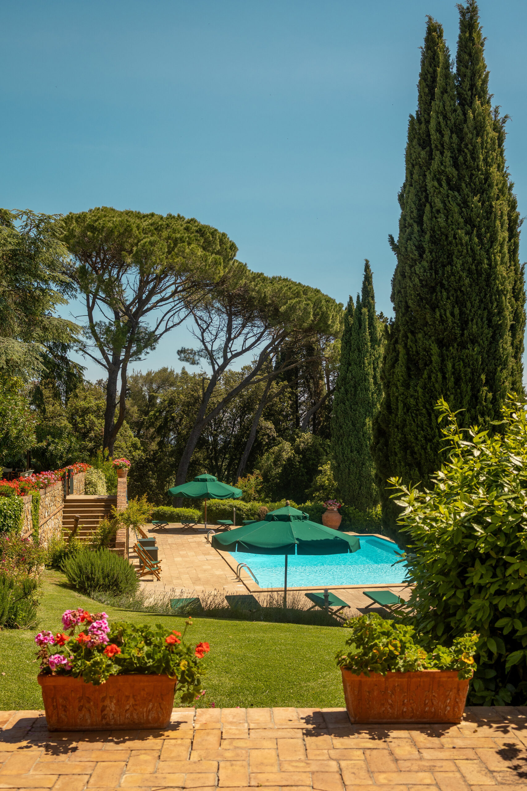 La piscina di Villa Piaggia tra cipressi e casale in pietra