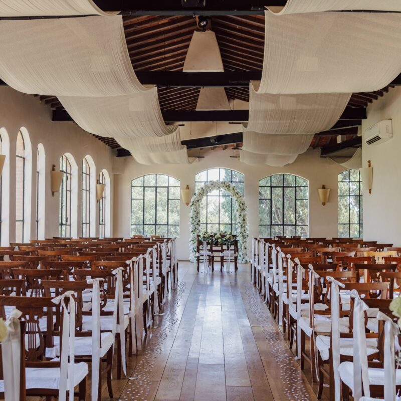 Sala della cerimonia di Villa Dianella allestita con arco floreale bianco, vista dal fondo