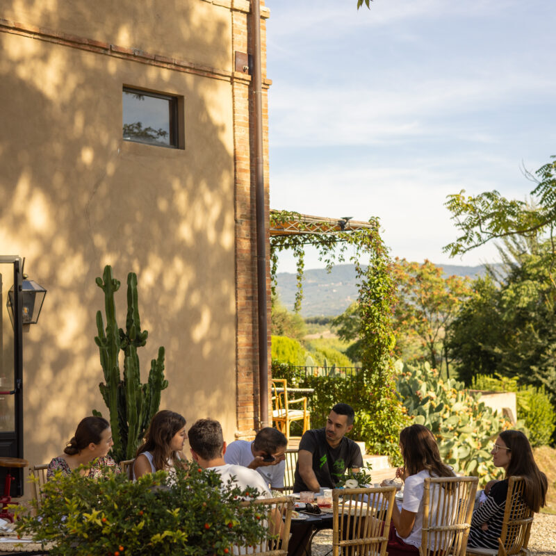 Ospiti a tavola in terrazza a Villa Dianella con vista sulle colline