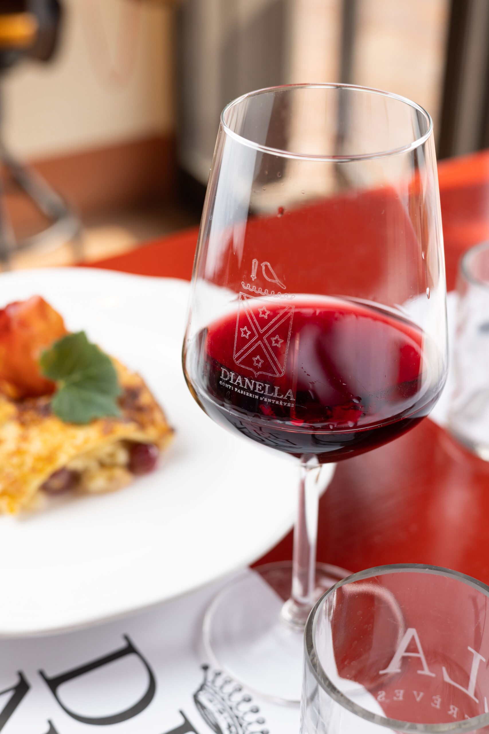 Table with a glass of wine and an autumn dish in the courtyard of Bistrot delle Scuderie, Villa Dianella